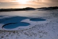 Rakes in bunkers at dawn on a snow covered course