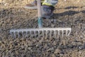 Raking gravel - leveling it - using a steel rake on a wooden style - handle.