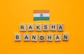 Raksha Bandhan, flag of India, minimalistic banner with inscription in wooden letters Royalty Free Stock Photo