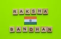 Raksha Bandhan, flag of India, minimalistic banner with the inscription in wooden letters on a green background Royalty Free Stock Photo