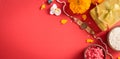 Raksha Bandhan, Indian festival with beautiful Rakhi and Rice Grains on red background. A traditional Indian wrist band which is