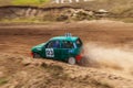 Rally off-road car make a turn with the clouds and splashes of sand, gravel and dust during rally championship