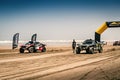 Rally raid cars racing away from the start of the Morocco Desert Challenge 2023. Driving on the beach of Plage Blanche.