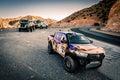 Rally raid trucks on a road in the mountains of Morocco. Morocco Desert Challenge 2023.