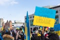 Rally in support of Ukraine against war. Protest and march against Russian invasion. Ukrainian flags and placard Stand
