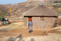 Ramabanta, Lesotho adult african woman in traditional blanket clothes stands at home in village, old basotho woman near clay house