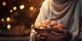 Ramadan banner with woman hands holdin bowl with dates.