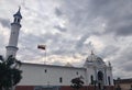Mosque Minaret and Dome with National Flag Under Cloudy Sky Royalty Free Stock Photo