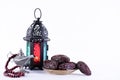 Ramadan food and drinks concept. Ramadan Lantern with arabian lamp, wood rosary, dates fruit and lighting on white background Royalty Free Stock Photo