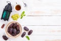 Ramadan food and drinks concept. Ramadan Lantern with tea, dates fruit, grape and Mint leaves on a white wooden table background. Royalty Free Stock Photo