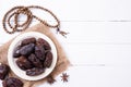 Ramadan food and drinks concept. Wood rosary, milk and dates fruit on a white wooden table background. Top view, Flat lay Royalty Free Stock Photo