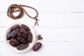 Ramadan food and drinks concept. Wood rosary, milk and dates fruit on a white wooden table background. Top view, Flat lay Royalty Free Stock Photo