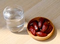 Ramadan iftar food, date fruits and glass od water on wooden table