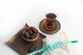 Ramadan Kareem Festival, Dates on wooden bowl with cup of black tea and rosary on white background