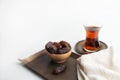 Ramadan Kareem Festival, Dates on wooden bowl with cup of black tea and rosary on white background