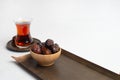Ramadan Kareem Festival, Dates at wooden bowl with cup of black tea on white isolated background Royalty Free Stock Photo