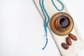 Ramadan Kareem Festival, Dates on wooden bowl with cup of black tea and rosary on white isolated background