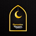 Ramadan Kareem with gold yellow white lettering and hanging crescent moon star in window border against dark brick wall background Royalty Free Stock Photo