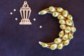 Ramadan kareem with qatayef arranged in shape of crescent moon. Traditional middle estern ramadan sweets. Iftar food concept.