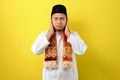 In Ramadan Kareem Young Asian Muslim Man try to cover his ears to do not listen useful things when fasting, His ears covered by