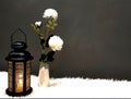 The Ramadan lantern is black, luminous, and its sides are decorated with wooden decorations, placed next to a small vase