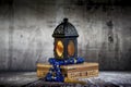 Ramadan lantern  lighten up and a Blue Arabic rosary over an arabesque box in a vintage mood or environment Royalty Free Stock Photo