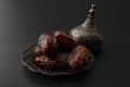 Ramadan sweets and middle eastern dried fruit concept with close up on serving of dry dates on beautifully ornate metal plate