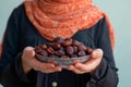 Ramadan tradition Muslim woman with plate of sweet dates during iftar