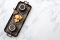 Ramadan treat and arabian hospitality concept with turkish baklava and mini coffee cups on authentic mediterranean metal tray