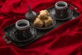 Ramadan treat and arabian hospitality concept with turkish baklava and mini coffee cups on authentic mediterranean metal tray