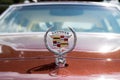 Vintage Cadillac hood ornament on red background