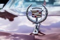 Vintage Cadillac hood ornament on red background