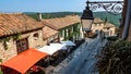 View beyond lantern on small street with restaurants in mediterranean village