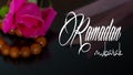 Ramazan Mubarak or Ramadan Kareem. Pink rose and rosary on a black background. Ramadan mubarak text in the image.