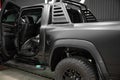 Rambar car, covered with protective matte black paint film, is in repair shop