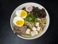 Ramen: Asian noodle soup with beef, eggs, fungi, vegetables, seaweed and naruto in a bowl Royalty Free Stock Photo