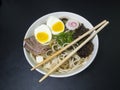 Ramen: Asian noodle soup with beef, eggs, fungi, vegetables, seaweed and naruto with chopsticks on the bowl Royalty Free Stock Photo