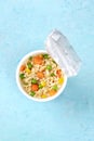 Ramen cup, instant noodles in a plastic cup on a blue background, shot from the top Royalty Free Stock Photo