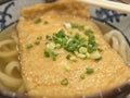 Ramen or Japanese noodles topping with deep fried tofu and scallions in clear soup Royalty Free Stock Photo