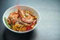 Ramen wheat noodles with mussels, shrimps and vegetables fried in a wok in a white bowl on black. Selective focus. Close up. Tasty Royalty Free Stock Photo