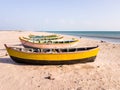 Colorful wooden fishing boats idling on a quiet white sand beach in the island of
