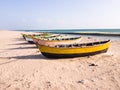 Colorful wooden fishing boats idling on a quiet white sand beach in the island of
