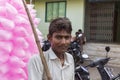 A portrait of a poor young Hard working man selling cotton candy taffy to tourists.