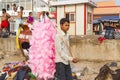 A portrait of a poor young Hard working man selling cotton candy taffy to tourists.