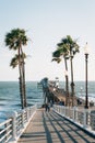Ramp to the pier and palm trees overlooking the Pacific Ocean, in Oceanside, San Diego County, California