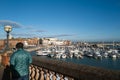 Ramsgate, UK - Nov 18 2020 Ramsgate Royal Harbour lit by late afternoon winter sunshine as a local man walks by a balustrade