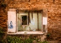 Ramshackle window includes another window, parts of an abandoned tumbledown house, uninhabitable condition, firebricks