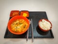 Ramyeon, Korean instant noodle dish. Kimchi, yellow pickled radish and a bowl of white rice.