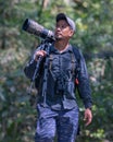 Local Young man traveler with carrying photography gear to taking photo of wildlife on Rainforest jungle