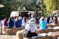 People seated on haystacks listening to a speech